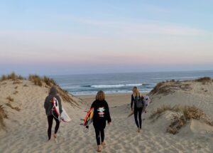 Drei Surfer am Weg zum Strand